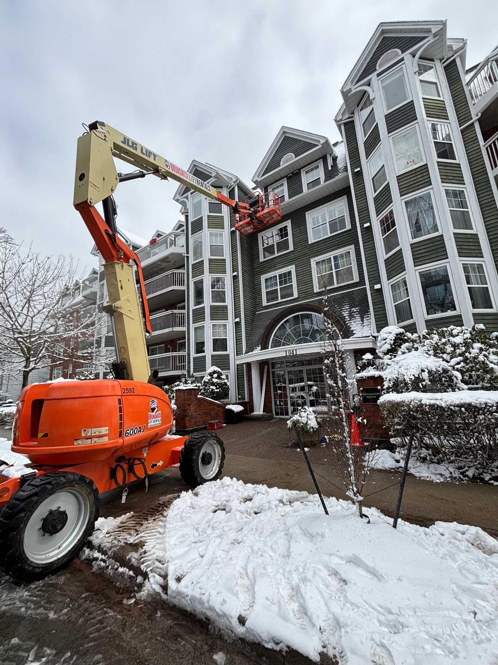 Boom lift extended to an upper exterior wall