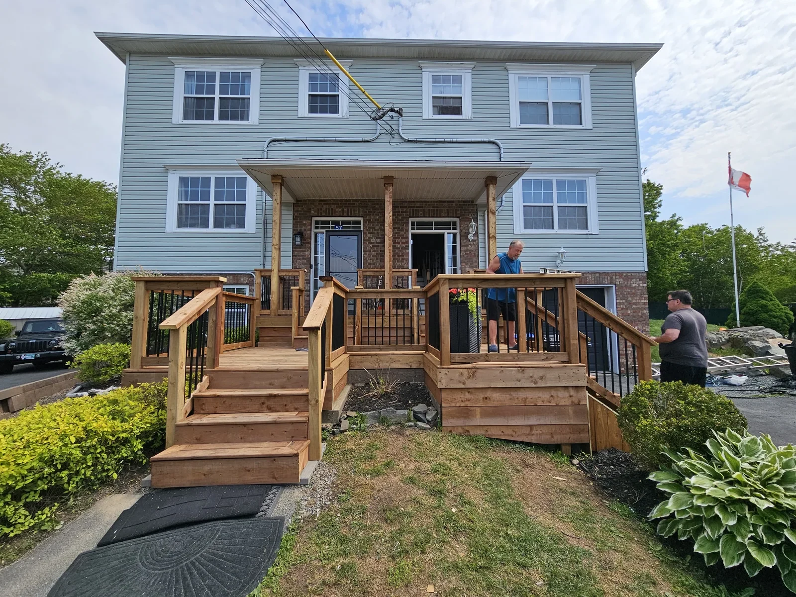 Finished front entry deck with black balusters and wide steps