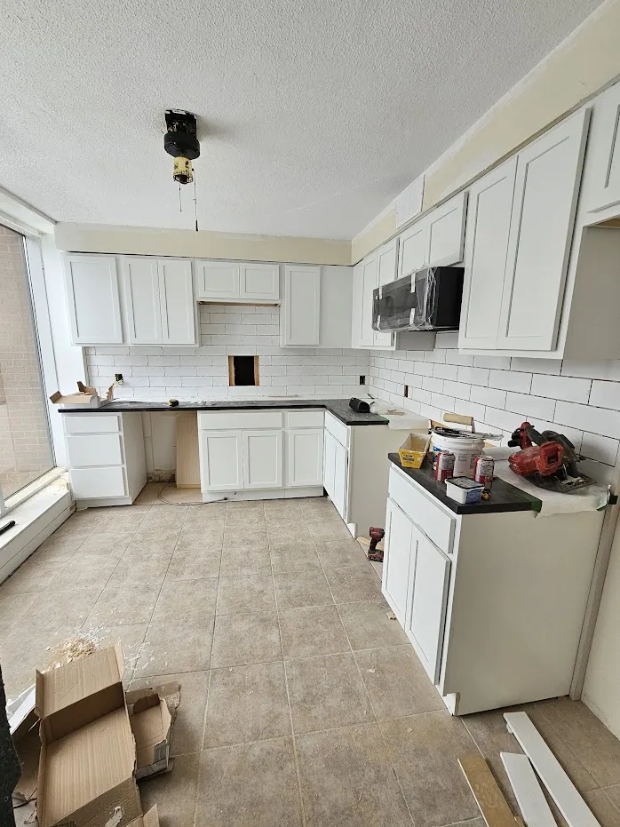 New cabinetry and subway-tile backsplash being installed